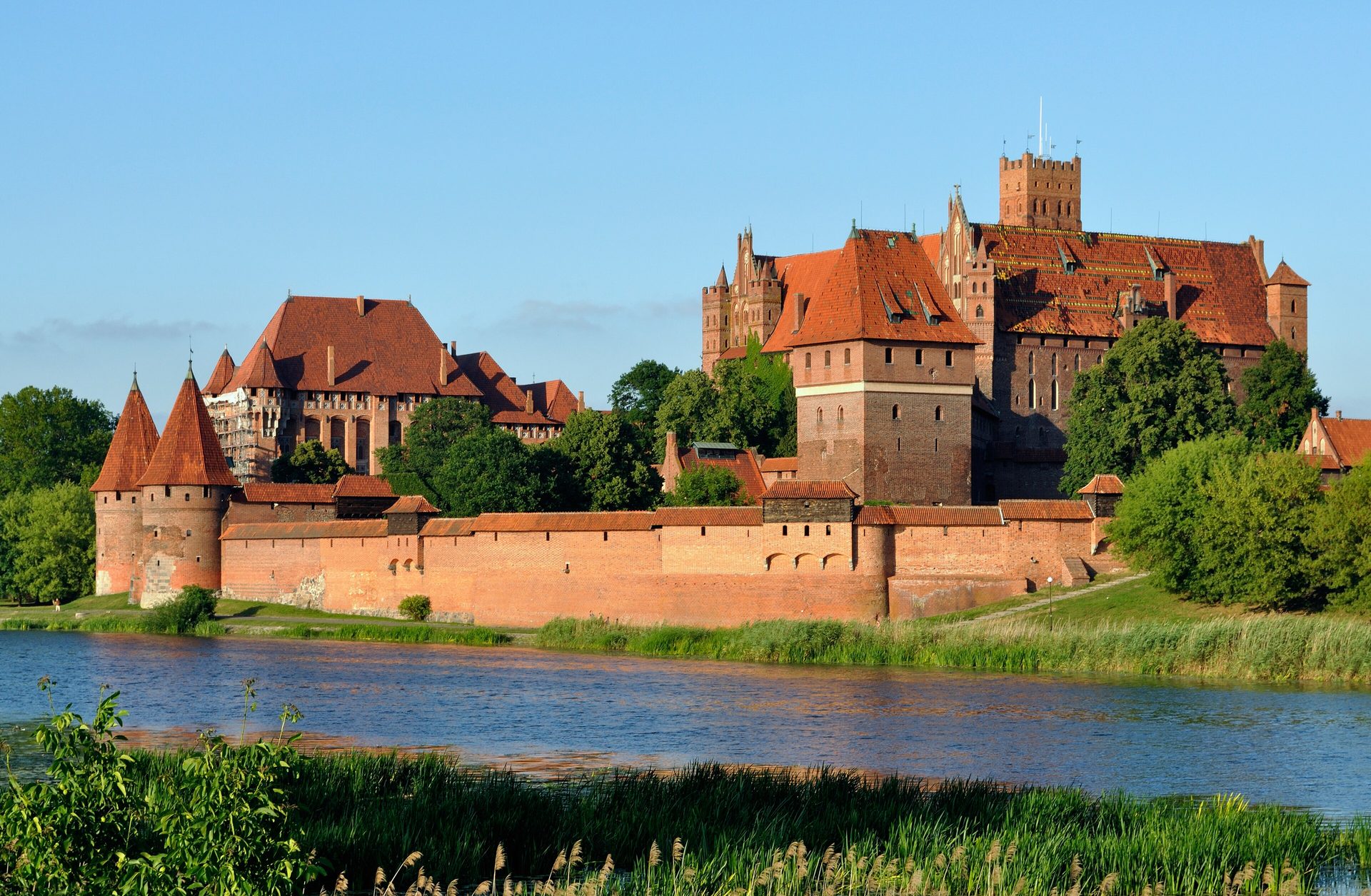 Malbork Castle’s red-brick walls and towers rising beside the Nogat River